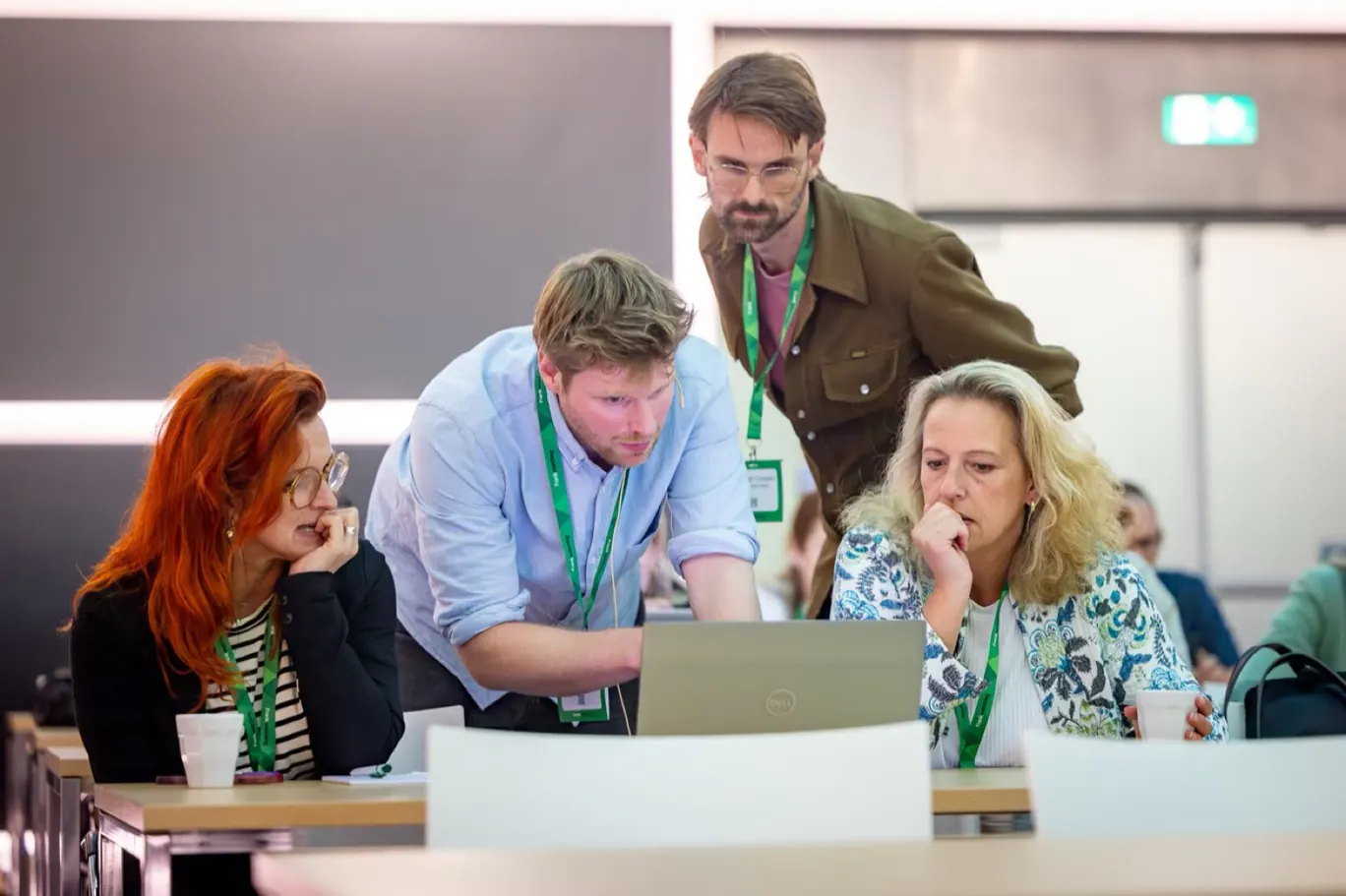 Teamwork during the hackathon: participants working together on laptops and strategy